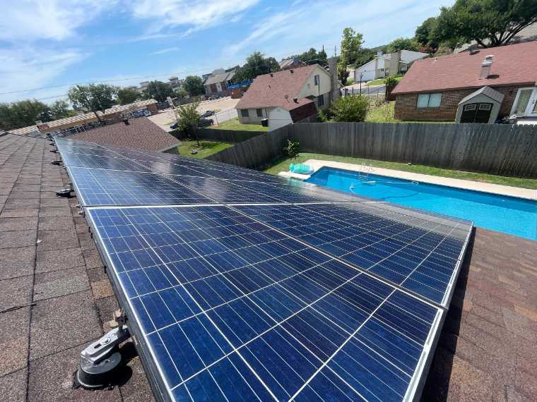 Clean solar panels on a home overlooking a pool