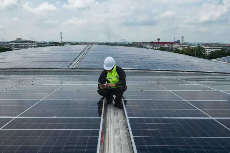 Technician inspecting a commercial solar array